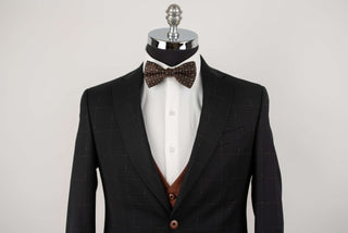 Black Quesste extended suit with plaid pattern and a brown vest