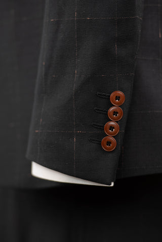 Black Quesste extended suit with plaid pattern and a brown vest