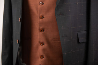 Black Quesste extended suit with plaid pattern and a brown vest